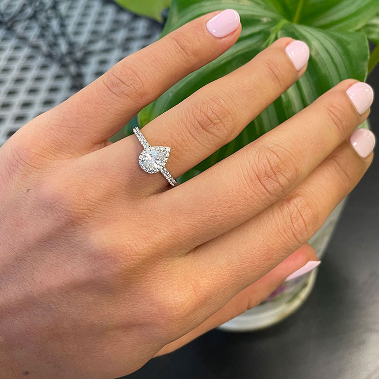 Pear cut diamond engagement ring with halo and diamond band
